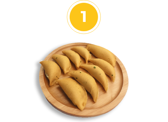 empanadas arranged on a round wooden cutting board